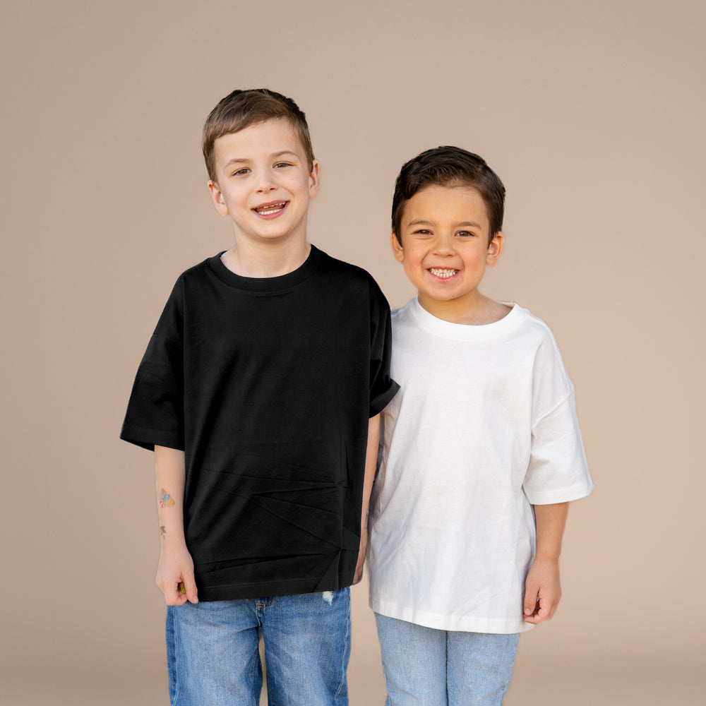 Two children wearing black and white t-shirts against a beige background