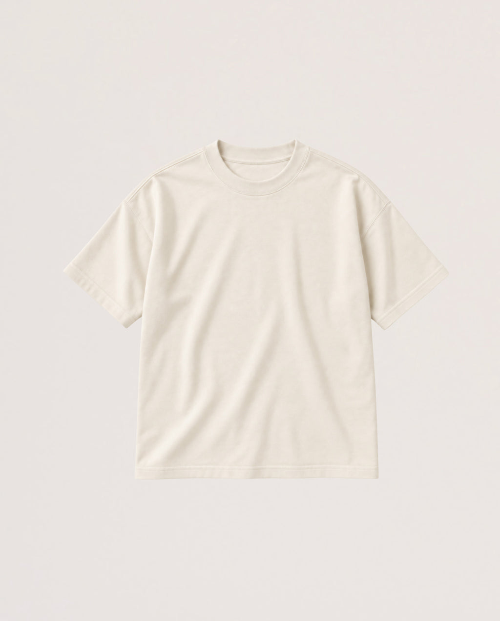 A plain short-sleeve crewneck t-shirt in a warm off-white or cream color, laid flat against a matching light beige background.
