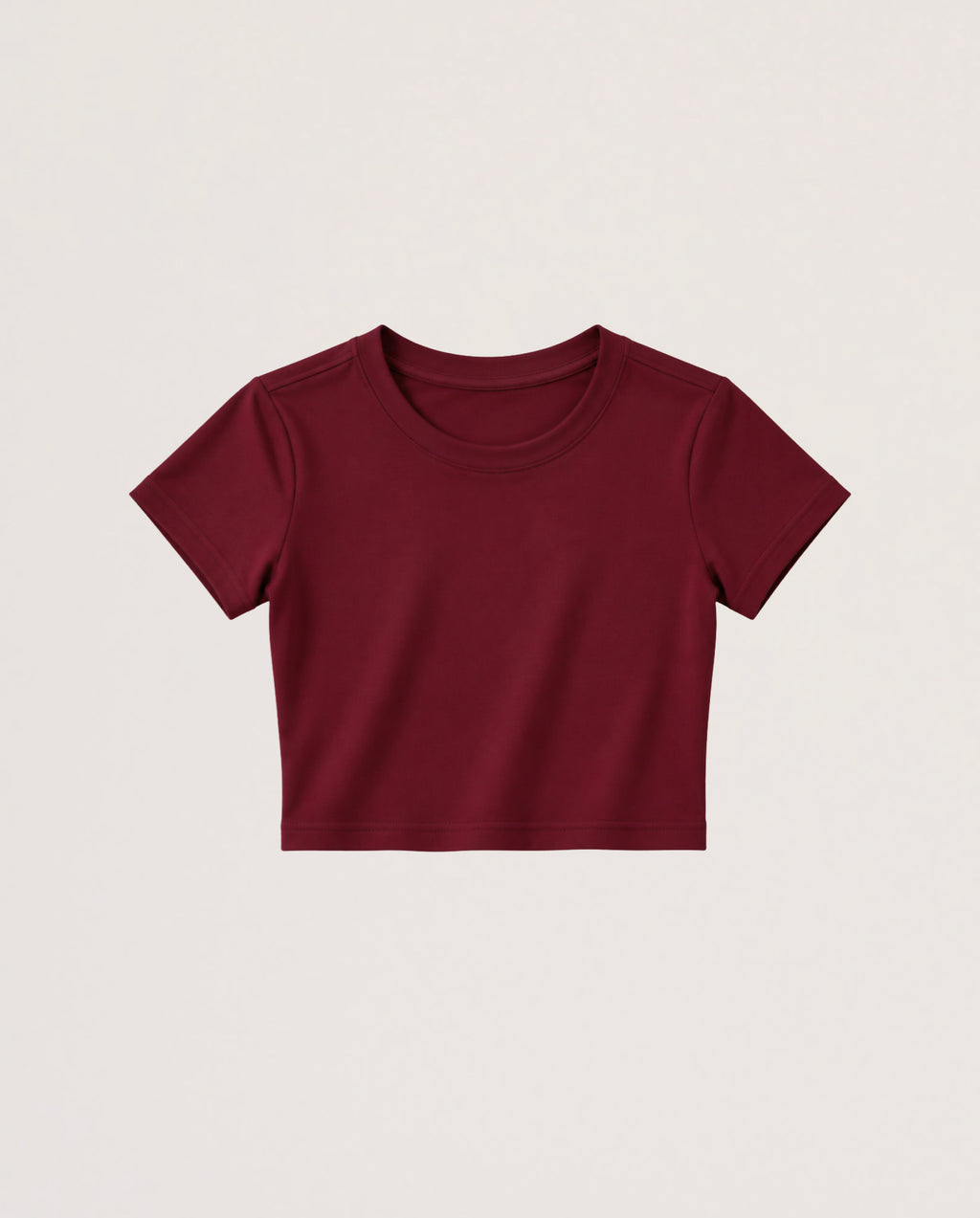 A short-sleeve crewneck crop top in burgundy, presented flat against a light beige background.