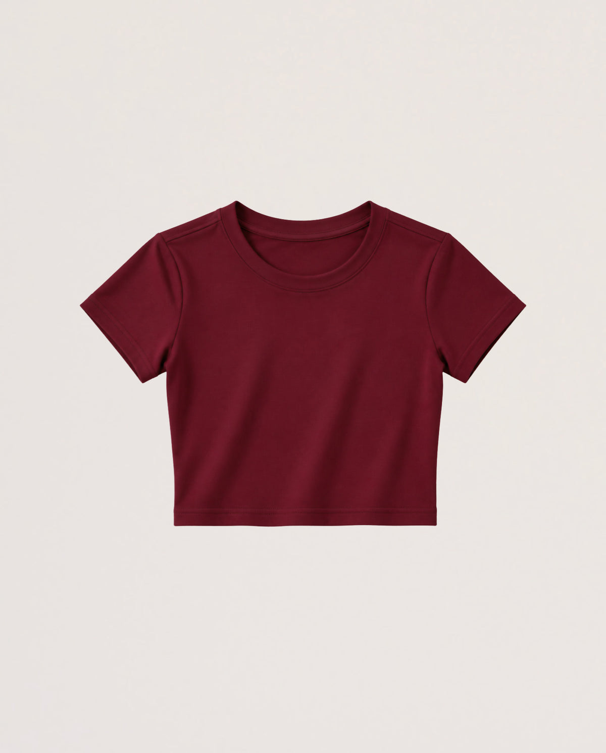 A short-sleeve crewneck crop top in burgundy, presented flat against a light beige background.