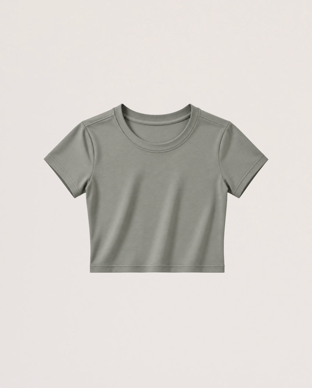 A short-sleeve crewneck crop top in a muted sage green color, presented flat against a light beige background.