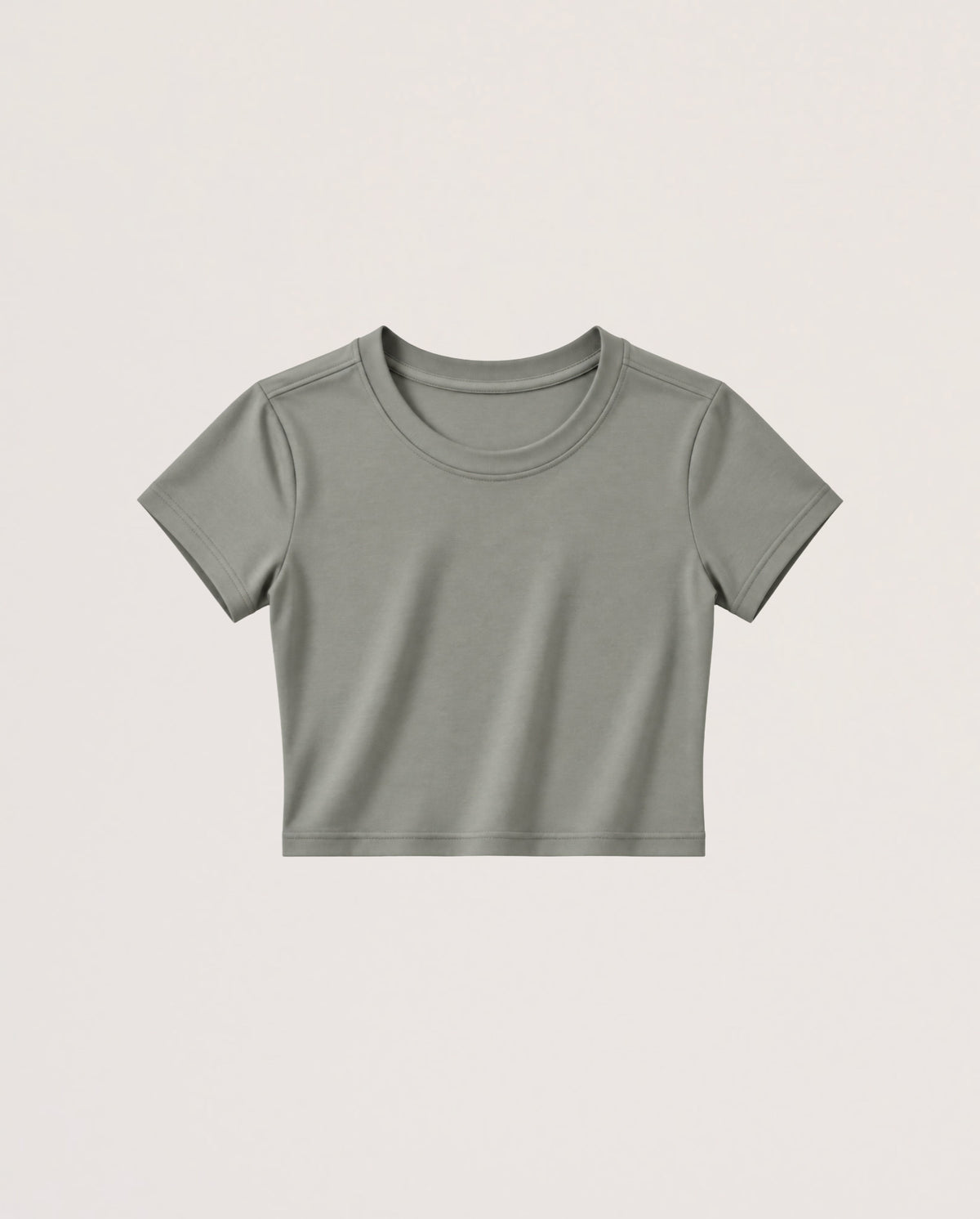 A short-sleeve crewneck crop top in a muted sage green color, presented flat against a light beige background.