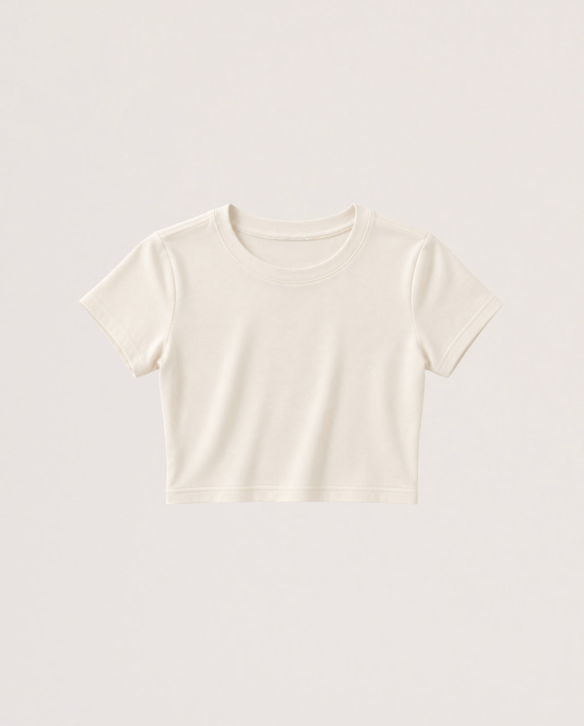 A short-sleeve cropped crewneck t-shirt in a warm off-white or cream color, presented flat against a matching light beige background.