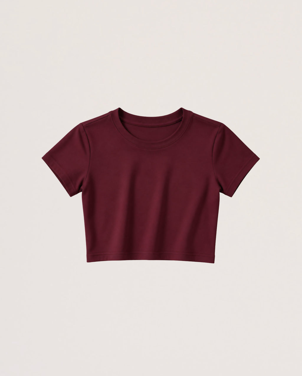 A short-sleeve crewneck crop top in burgundy, displayed flat against a light beige background.