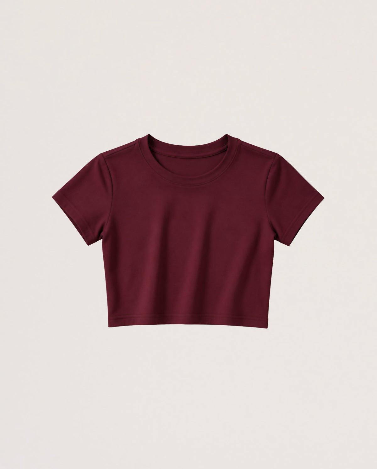 A short-sleeve crewneck crop top in burgundy, displayed flat against a light beige background.
