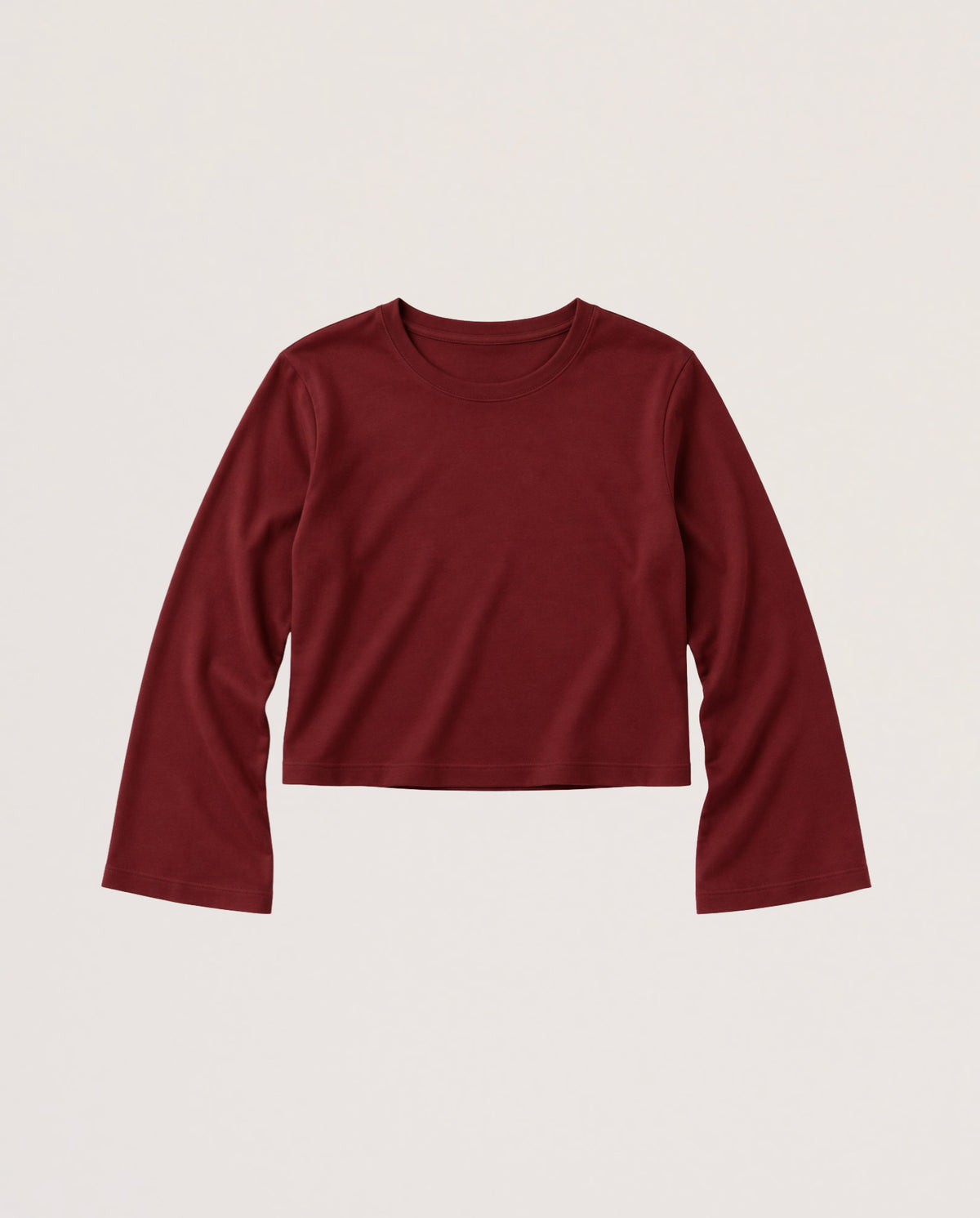 A dark red long-sleeve cropped t-shirt with a crew neck, displayed flat against a light beige background.